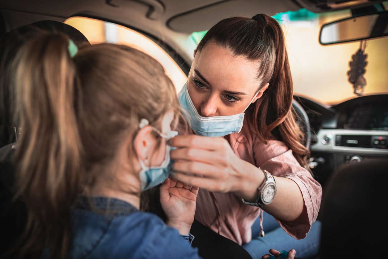 Woman in protective mask waiting on road