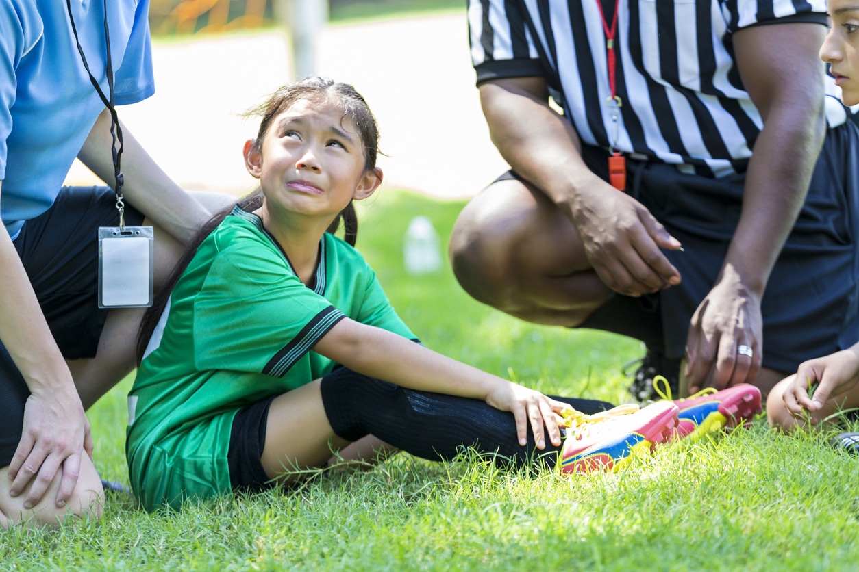 treat sports injuries in kids with coach, ref, and little girl