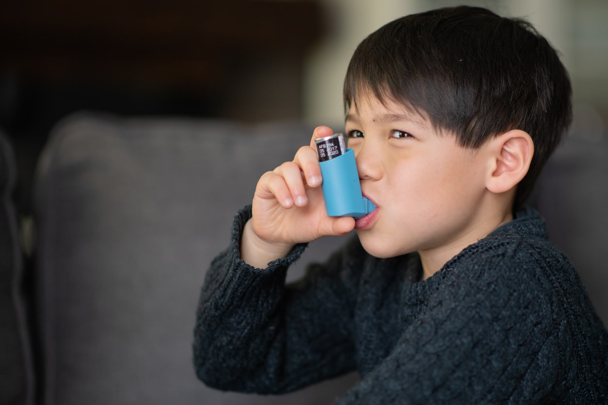 little boy with inhaler for asthma in children