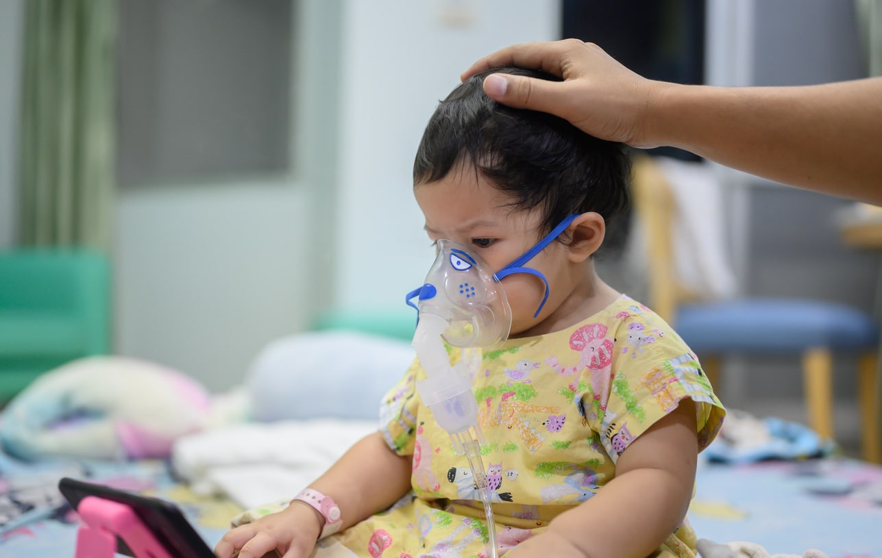 Little girl with RSV in Children with a breathing treatment mask on