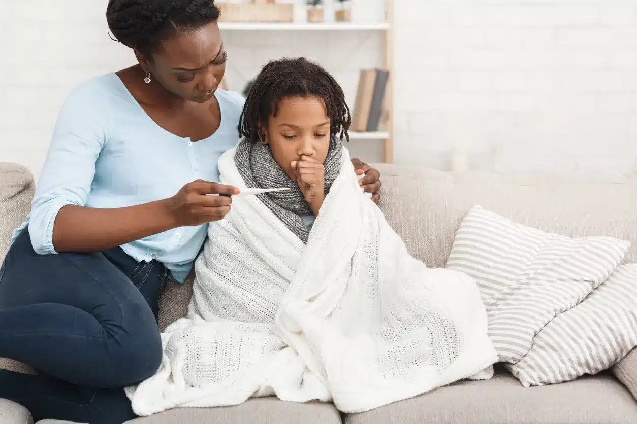 Mother checks the temperature of her sick child.