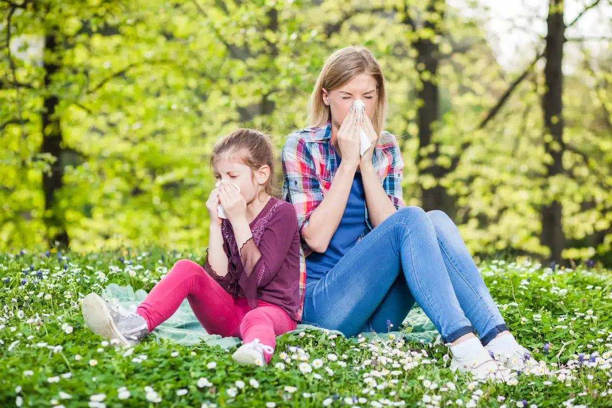 Mother and daughter blow their noses on a beautiful, pollen-filled spring day.