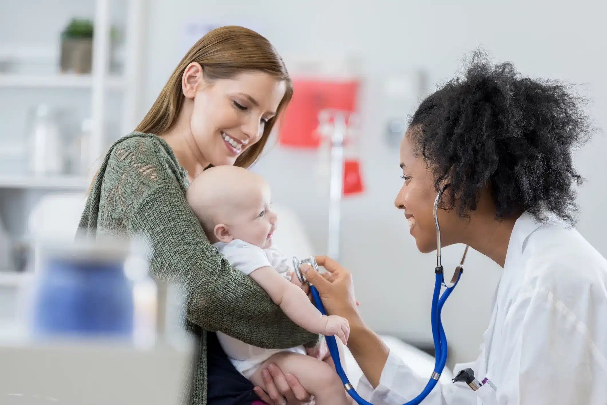 Friendly urgent care pediatrician examines infant